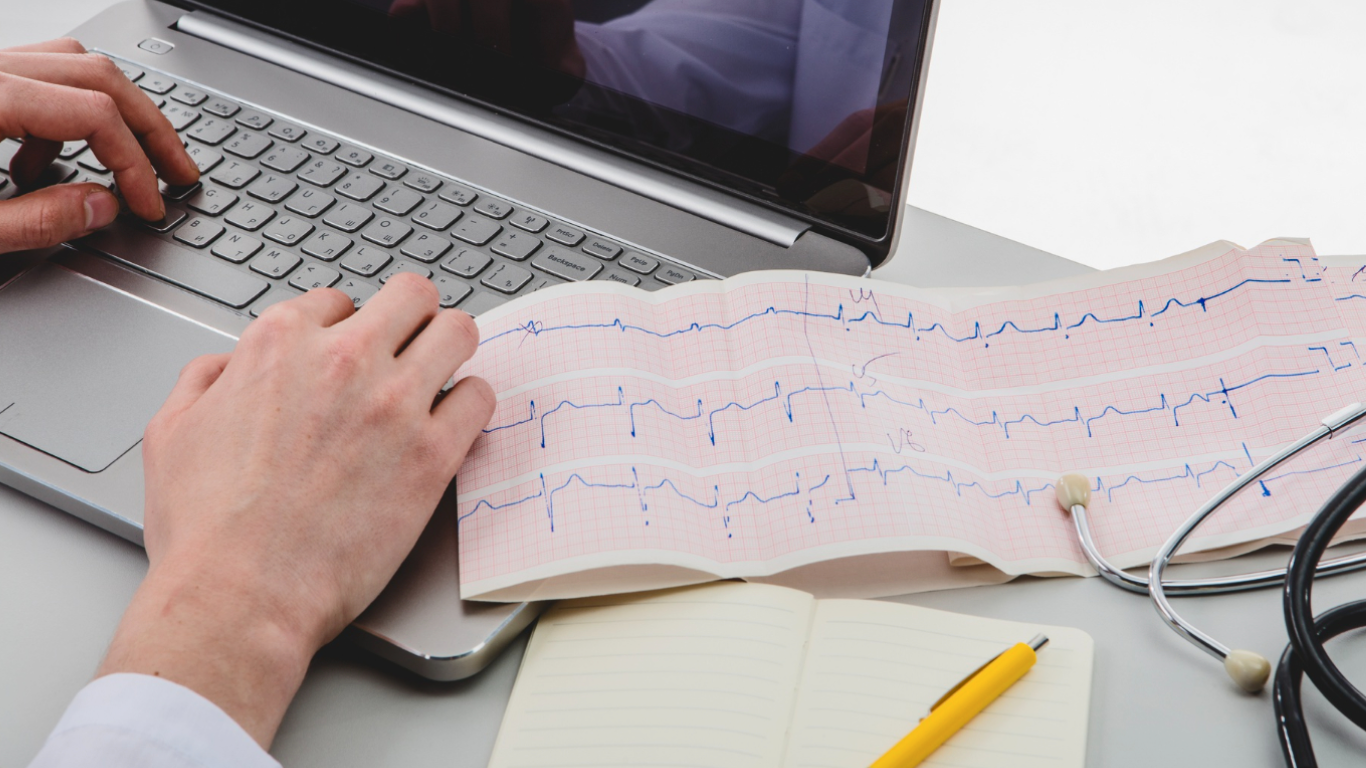 Médico no computador, analisando um dos exames do check-up cardiológico