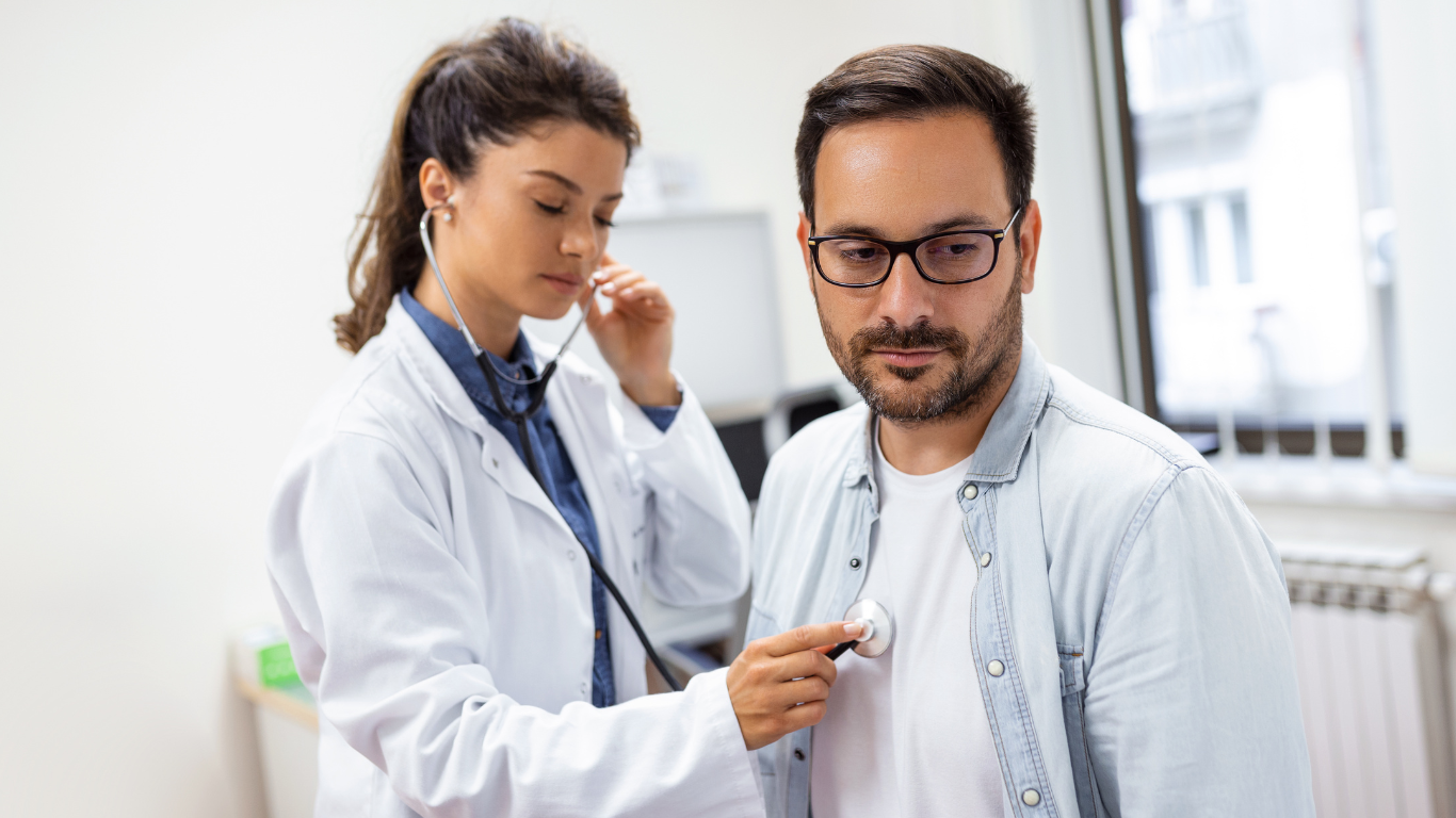 Homem sendo examinado pela médica durante o tratamento para insuficiência cardíaca