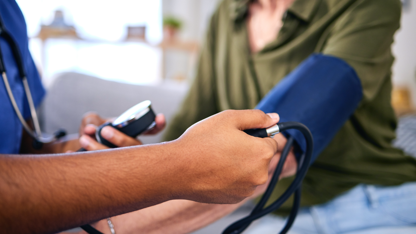 Profissional medindo a pressão do paciente, para falar de hipertensão e atividade física